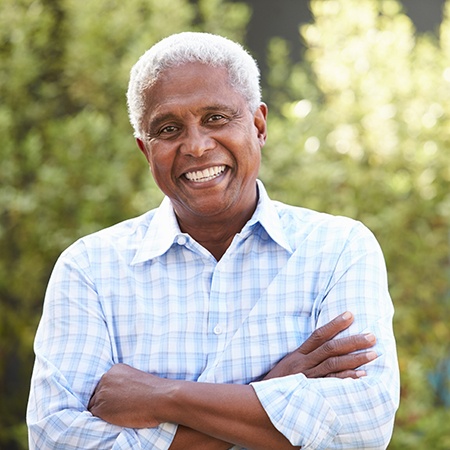 Senior man smiling with arms folded