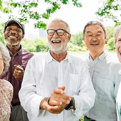 Dentures patient in San Marcos smiling with friends