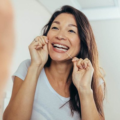 a woman flossing her teeth