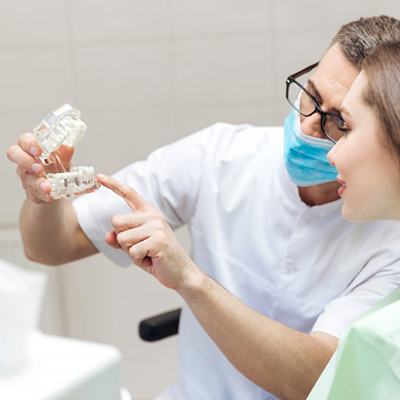 a dentist explaining how dental implants work to a patient